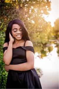 Girl in black dress for Senior Portrait Photoshoot by the lake in Round Rock Texas by Natural Light Photographer