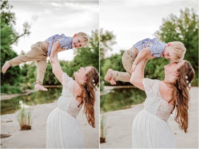 Mother and son cuddling and laughing during maternity photoshoot in Austin Texas park white lace dress with flowers and braids in hair