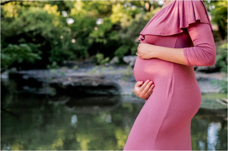 Expecting mother in pink maxi dress during maternity photoshoot natural light family photographer austin texas