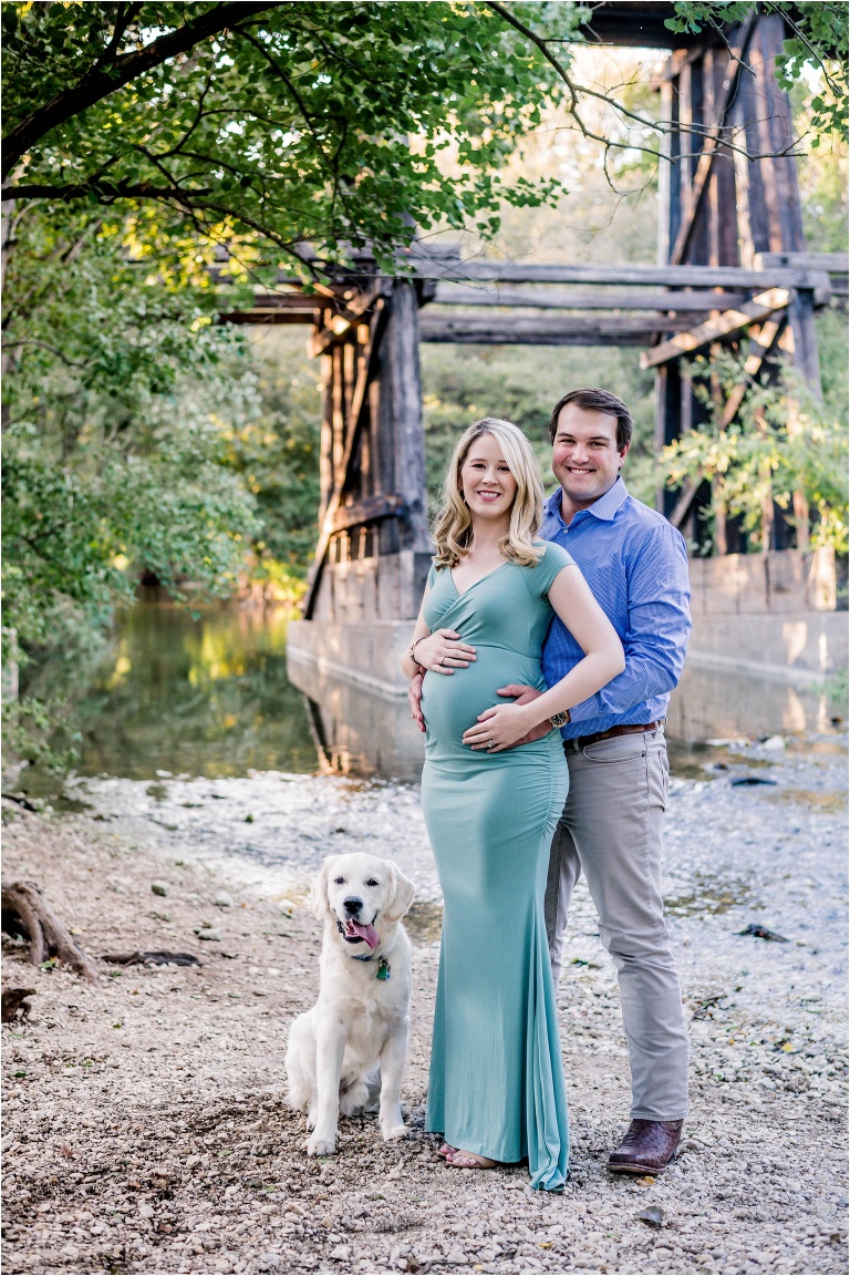 couple during maternity photoshoot near creek with golden retriever puppy cedar park texas photographer