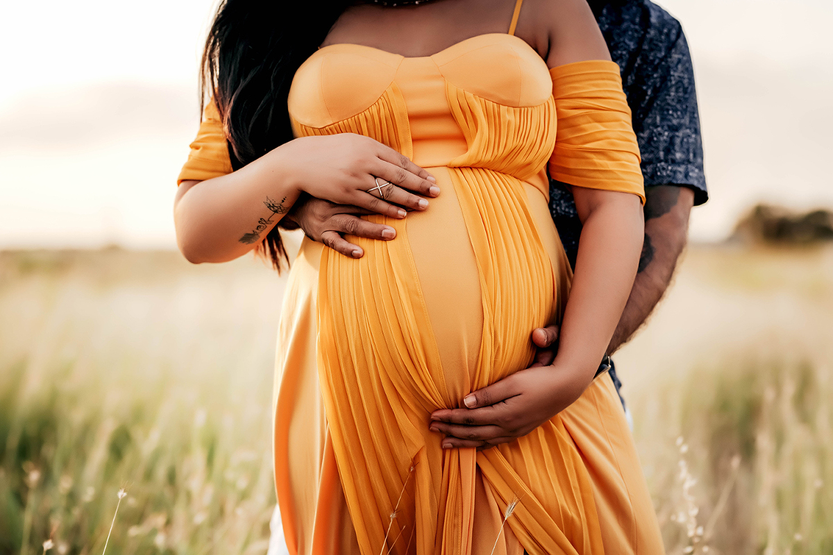 Maternity photoshoot with couple in long grassy field in Round Rock Texas
